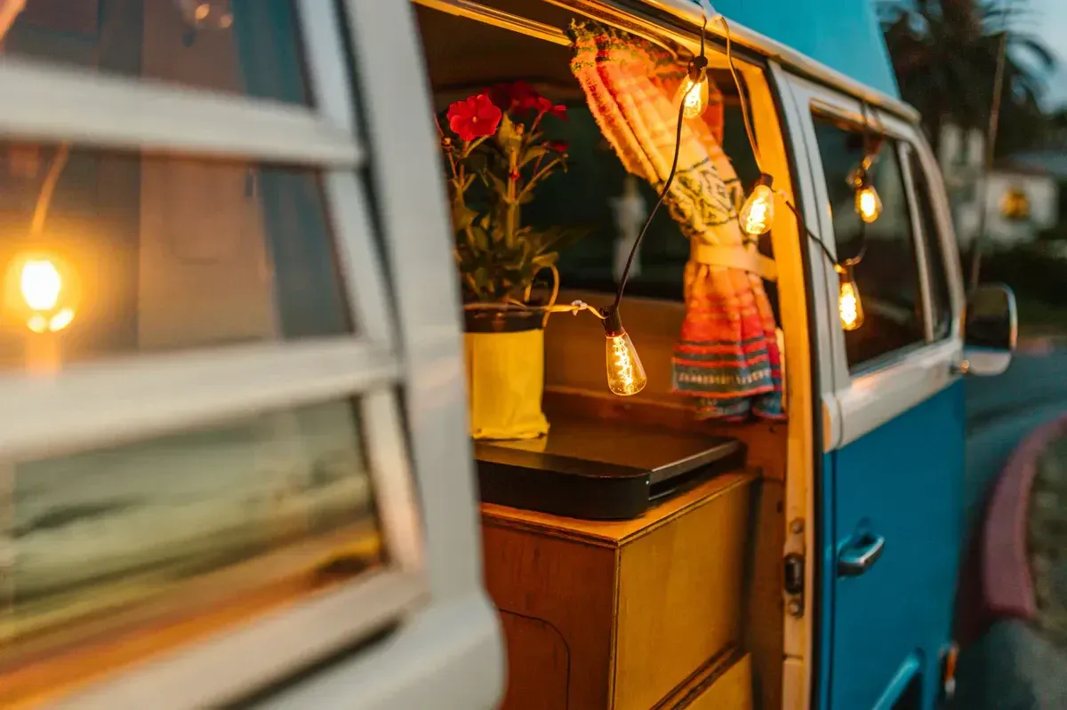 The interior of a camper van glowing with warm light at night, a cozy heated vanlife scene for diesel heater context